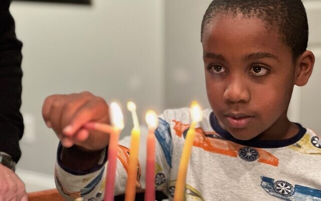 Jack Kulbersh allume une menorah. (Crédit : Project Menorah)