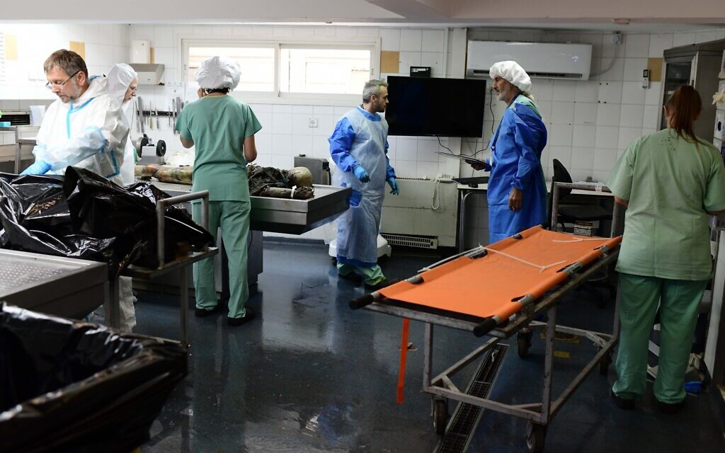 Le personnel de la médecine légale examine le corps décomposé non identifié d'une victime de l'attaque meurtrière du Hamas sur les communautés du sud d'Israël le 7 octobre 2023 au Centre national de médecine légale (Abu Kabir) à Jaffa, le 16 octobre 2023. (Crédit : Tomer Neuberg/Flash90)