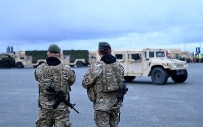 Des soldats danois patrouillant dans la zone du port d'Aarhus, au Danemark, où sont stationnés des véhicules militaires de l'armée américaine, le 16 janvier 2023. (Crédit : Sergei Gapon/AFP)