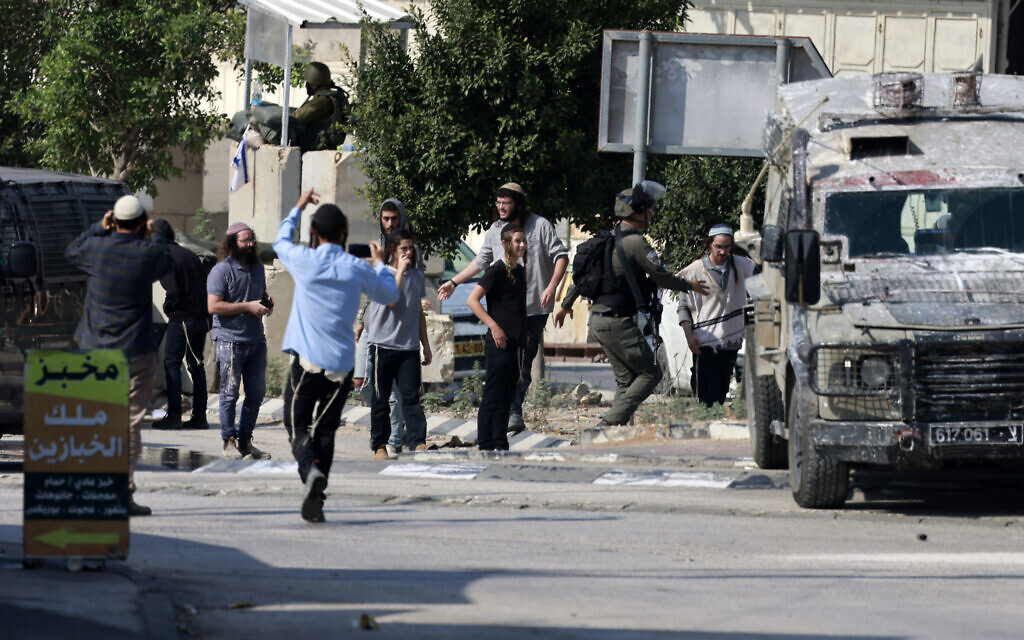 Des soldats israéliens se confrontant à des résidents de l'implantation d'Einav qui tentent d'attaquer la ville de Deir Sharaf, dans le gouvernorat de Naplouse,  suite à un attentat terroriste qui a tué un conducteur israélien au volant de sa voiture, le 2 novembre 2023. (Crédit : Jaafar Ashtiyeh/AFP)