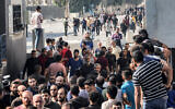 Des ouvriers palestiniens, bloqués en Israël depuis les attaques du 7 octobre, retraversant la bande de Gaza au poste-frontière de Kerem Shalom avec Israël, dans le sud de l'enclave palestinienne, le 3 novembre 2023. (Crédit : Saïd Khatib/AFP)