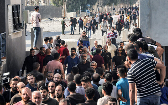 Des ouvriers palestiniens, bloqués en Israël depuis les attaques du 7 octobre, retraversant la bande de Gaza au poste-frontière de Kerem Shalom avec Israël, dans le sud de l'enclave palestinienne, le 3 novembre 2023. (Crédit : Saïd Khatib/AFP) Des ouvriers palestiniens, bloqués en Israël depuis les attaques du 7 octobre, retraversant la bande de Gaza au poste-frontière de Kerem Shalom avec Israël, dans le sud de l'enclave palestinienne, le 3 novembre 2023. (Crédit : Saïd Khatib/AFP)