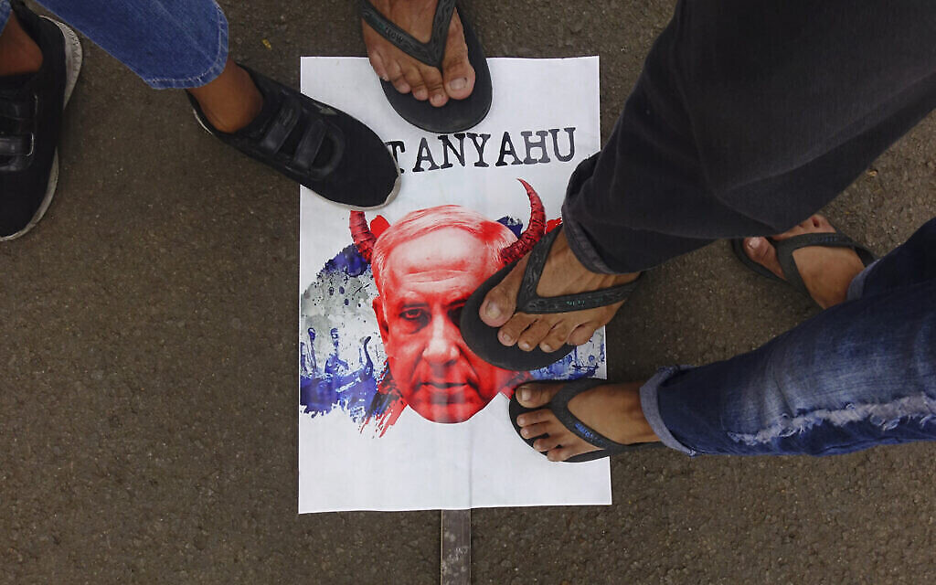 Des personnes marchent sur une caricature du Premier ministre Benjamin Netanyahu lors d'un rassemblement en solidarité avec les Palestiniens, au Monument national de Jakarta, le 5 novembre 2023. (Photo d'Azwar IPANK / AFP)