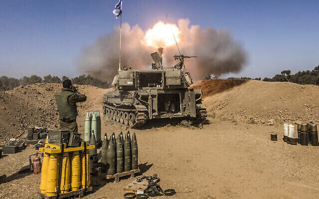 Un soldat israélien se bouche les oreilles alors qu'un obusier d'artillerie automoteur tire des obus depuis une position près de la frontière avec la bande de Gaza, dans le sud d'Israël, le 6 novembre 2023. (Crédit : MENAHEM KAHANA / AFP) Un soldat israélien se bouche les oreilles alors qu'un obusier d'artillerie automoteur tire des obus depuis une position près de la frontière avec la bande de Gaza, dans le sud d'Israël, le 6 novembre 2023. (Crédit : MENAHEM KAHANA / AFP)
