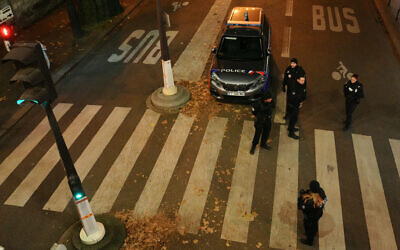 Des agents de police surveillent le périmètre de sécurité établi après la mort d'une personne lors d'une attaque au couteau qui a aussi fait deux blessés à Paris, en France, le 2 décembre 2023. (Crédit : Dimitar Dilkoff/AFP)