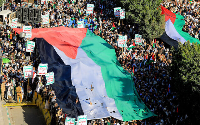 Des Yéménites brandissent des drapeaux et scandent des slogans lors d'une marche de solidarité avec la population de Gaza dans la capitale contrôlée par les Houthis, Sanaa, le 8 décembre 2023. (Crédit : MOHAMMED HUWAIS / AFP)