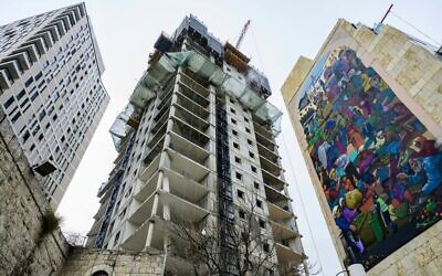 Une tour résidentielle en construction à côté du marché Mahane Yehuda dans le centre-ville de Jérusalem, le 7 décembre 2023. (Crédit : John MacDougall / AFP)