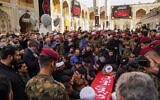 Des personnes en deuil prient sur le cercueil de Razi Moussavi, un haut commandant de la Force Qods du Corps des Gardiens de la révolution islamique (CGRI) d'Iran, tué le 25 décembre lors d'une frappe attribué à Israël en Syrie, lors de son cortège funèbre au sanctuaire de l'Imam Ali dans le lieu saint d'Irak de la ville de Najaf, le 27 décembre 2023. - (Crédit : Qassem al-KAABI / AFP)