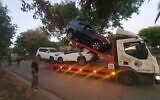 Une dépanneuse chargée de véhicules volés au kibboutz Beeri. (Crédit : Police israélienne)