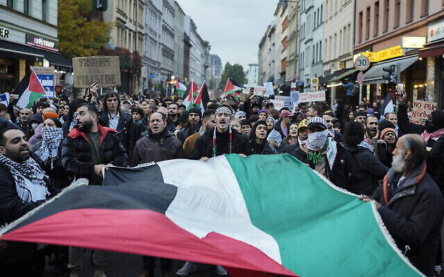 Des manifestants brandissent des pancartes et des drapeaux palestiniens lors d'un rassemblement pro-palestinien, à Berlin, en Allemagne, le 28 octobre 2023. (Crédit : AP Photo/Markus Schreiber) Des manifestants brandissent des pancartes et des drapeaux palestiniens lors d'un rassemblement pro-palestinien, à Berlin, en Allemagne, le 28 octobre 2023. (Crédit : AP Photo/Markus Schreiber)