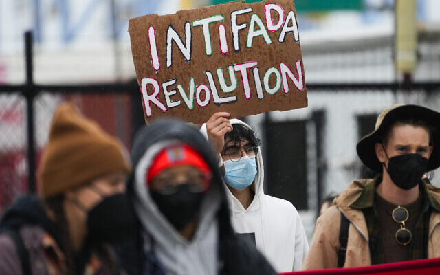 Illustration : Un manifestant tenant une pancarte "révolution intifada" alors que des manifestants bloquent les entrées du port de Tacoma, dans l'État de Washington, le 6 novembre 2023. (Crédit : Lindsey Wasson/AP Photo) Illustration : Un manifestant tenant une pancarte "révolution intifada" alors que des manifestants bloquent les entrées du port de Tacoma, dans l'État de Washington, le 6 novembre 2023. (Crédit : Lindsey Wasson/AP Photo)