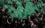 Des personnes agitent des drapeaux du Hamas tout en criant des slogans lors d'une manifestation pro-palestinienne et pro-Hamas après la prière du vendredi devant la mosquée de Beyazit à Istanbul, en Turquie, le 24 novembre 2023. (Crédit : Francisco Seco/AP)