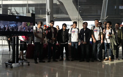 Le Premier ministre thaïlandais Srettha Thavisin, sur un écran à gauche, s'adresse aux ex-otages du Hamas thaïlandais, à leur arrivée à l'aéroport international Suvarnabhumi dans la province de Samut Prakarn, en Thaïlande, le 30 novembre 2023. (Crédit : AP Photo/Sakchai Lalit)