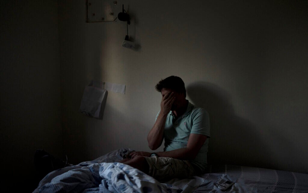 Eyal Barad s’arrêtant quelques instants dans la pièce sécurisée où il s'était abrité avec sa famille le 7-Octobre, alors que les terroristes du Hamas ont tué et capturé un quart de sa communauté du kibboutz Nir Oz, le 9 novembre 2023. (Crédit : Maya Alleruzzo/AP)