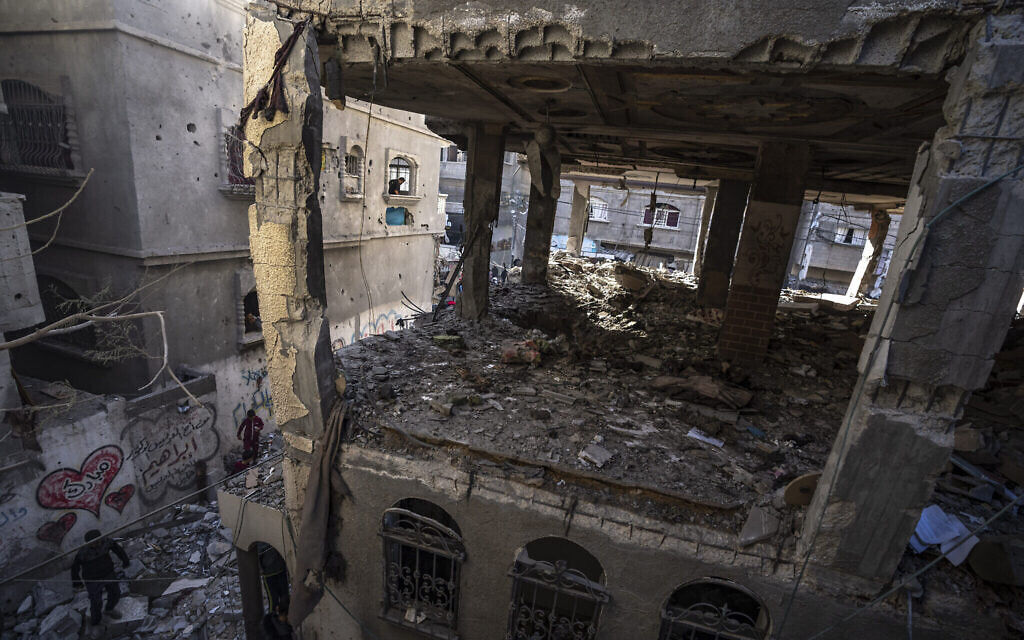 Des Palestiniens vérifiant une maison détruite lors d'une frappe israélienne, à Rafah, dans la bande de Gaza, le 11 décembre 2023. (Crédit : Fatima Shbair/AP Photo)