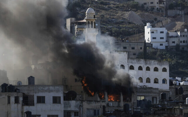 Le feu et la fumée s’élevant lors d'une opération de l'armée israélienne à Jénine, en Cisjordanie, le 13 décembre 2023. (Crédit : Majdi Mohammed/AP Photo) Le feu et la fumée s’élevant lors d'une opération de l'armée israélienne à Jénine, en Cisjordanie, le 13 décembre 2023. (Crédit : Majdi Mohammed/AP Photo)