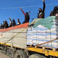 Des terroristes du Hamas sur un camion d'aide humanitaire à Rafah, dans la bande de Gaza, le 19 décembre 2023. (Crédit : AP Photo)