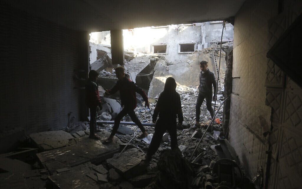 Des Palestiniens constatent les destructions après une frappe israélienne à Rafah, dans la bande de Gaza, le dimanche 24 décembre 2023. (Crédit : AP/Hatem Ali)