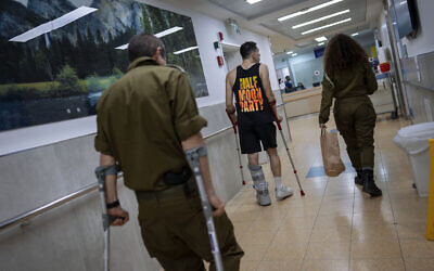 Des soldats de l’armée israélienne blessés dans la guerre contre le Hamas marchant dans la division de réhabilitation de l'hôpital de Sheba, à Ramat Gan, le 18 décembre 2023. (Crédit : Oded Balilty/AP)