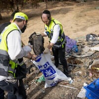 Le personnel du service de secours ZAKA collectant des vêtements qui appartenant aux victimes du massacre du Hamas du 7 octobre, près de la frontière entre Israël et Gaza, dans le sud d'Israël, le 19 novembre 2023. (Crédit : Chaïm Goldberg/Flash90)