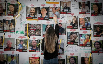 Des Israéliens plaçant des affiches des personnes retenues en otage par les terroristes du Hamas à Gaza, sur la "Place des Otages", à Tel Aviv, le 6 décembre 2023. (Crédit : Miriam Alster/FLASH90)