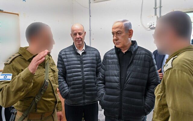 Le Premier ministre Benjamin Netanyahu, à droite, et le conseiller à la Sécurité nationale Tzahi Hanegbi rencontrant des officiers de l’armée israélienne lors d'une visite d'une installation militaire dans le sud d'Israël, le 13 décembre 2023. (Crédit : Kobi Gideon/GPO)