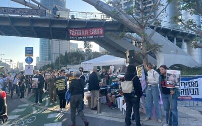 Des familles d'otages bloquant la sortie du ministère de la Défense, à Tel Aviv, à 14h29, le 19 décembre 2023. (Crédit : Jessica Steinberg/Times of Israel)