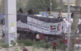 Des terroristes armés et masqués, vraisemblablement affiliés au Hamas, sur des camions transportant de l'aide humanitaire qui sont arrivés dans la bande de Gaza via le point de passage de Rafah, en Égypte, le 17 décembre 2023. (Crédit : Capture d'écran ; utilisée conformément à l'article 27a de la loi sur les droits d'auteur)