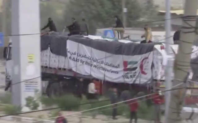 Des terroristes armés et masqués, vraisemblablement affiliés au Hamas, sur des camions transportant de l'aide humanitaire qui sont arrivés dans la bande de Gaza via le point de passage de Rafah, en Égypte, le 17 décembre 2023. (Crédit : Capture d'écran ; utilisée conformément à l'article 27a de la loi sur les droits d'auteur) Des terroristes armés et masqués, vraisemblablement affiliés au Hamas, sur des camions transportant de l'aide humanitaire qui sont arrivés dans la bande de Gaza via le point de passage de Rafah, en Égypte, le 17 décembre 2023. (Crédit : Capture d'écran ; utilisée conformément à l'article 27a de la loi sur les droits d'auteur)