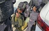Le surintendant principal Avi Amar, quelques heures avant qu'il ne soit tué, réconfortant un soldat de l'armée israélienne désemparé, à proximité du kibboutz Kfar Aza, le 7 octobre 2023. (Crédit : Police israélienne)