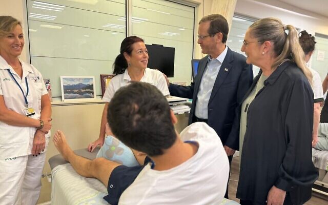 Le président Isaac Herzog et son épouse Michal Herzog (à droite) rendent visite à un soldat blessé et au personnel de l'hôpital de rééducation Loewenstein de Raanana, le 13 novembre 2023 (Avec l'aimable autorisation de l'hôpital Loewenstein)