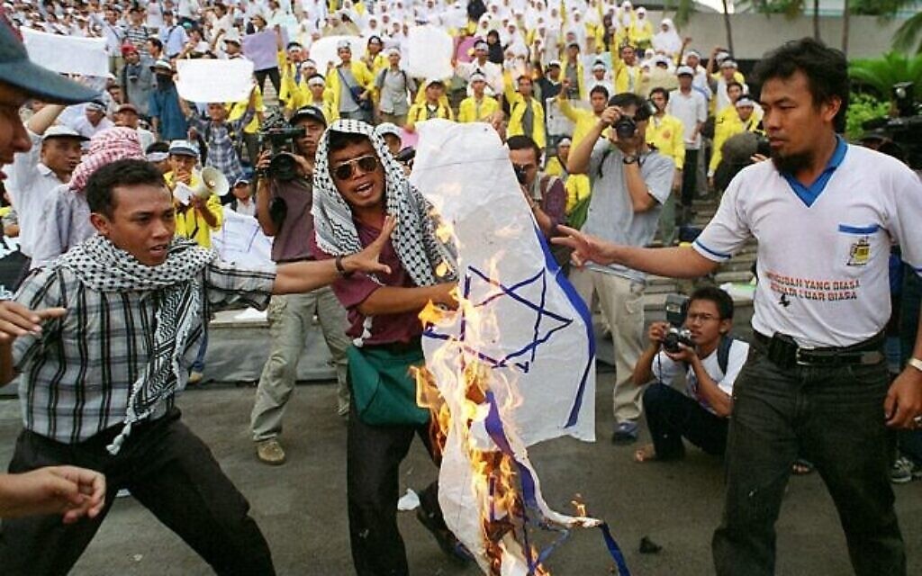 Illustration : Des étudiants islamiques indonésiens brûlent un drapeau israélien lors d'une manifestation devant le parlement national à Jakarta, le 11 novembre 1999, contre les projets du nouveau gouvernement d'entretenir des relations commerciales avec l'État juif. (Photo de KENZO TRIBOUILLARD / AFP)