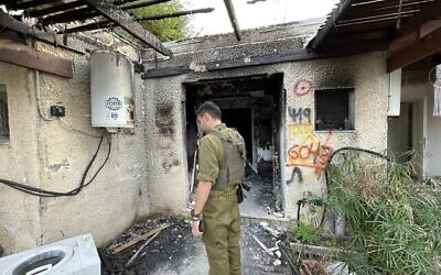 Un soldat israélien devant une maison détruite dans la communauté frontalière de Kfar Aza à Gaza, le 20 décembre 2023. (Crédit : Sam Sokol)