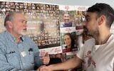 Mike Huckabee (à gauche) serrant la main de Moshe Lavi, dont le beau-frère Omri Miran a été enlevé au kibboutz Nir Oz le 7 octobre, à Tel Aviv le 20 décembre 2023. (Crédit : Sam Sokol/Times of Israel)