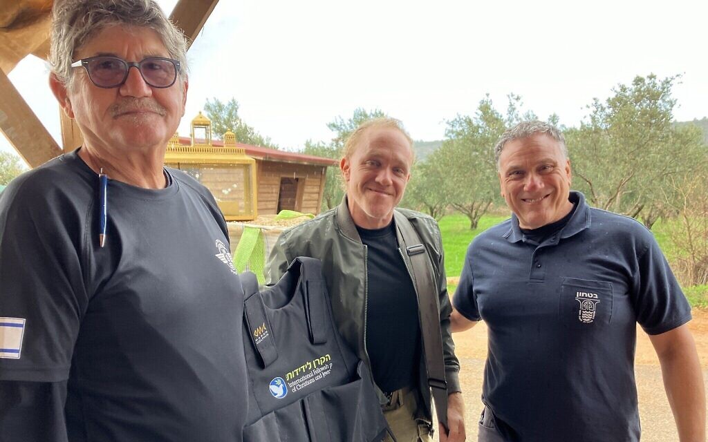 Shlomo Brand et Yishai Windmiller remettent des gilets offerts par l'Association internationale des chrétiens et des juifs à un membre de l'équipe de première intervention à Klil, en décembre 2023. (Crédit : Diana Bletter) Shlomo Brand et Yishai Windmiller remettent des gilets offerts par l'Association internationale des chrétiens et des juifs à un membre de l'équipe de première intervention à Klil, en décembre 2023. (Crédit : Diana Bletter)