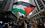 Illustration : Des manifestants anti-Israël brandissant des drapeaux palestiniens lors d'une manifestation à Toronto, Ontario, au Canada, le 9 octobre 2023. (Crédit : Cole Burston/AFP)