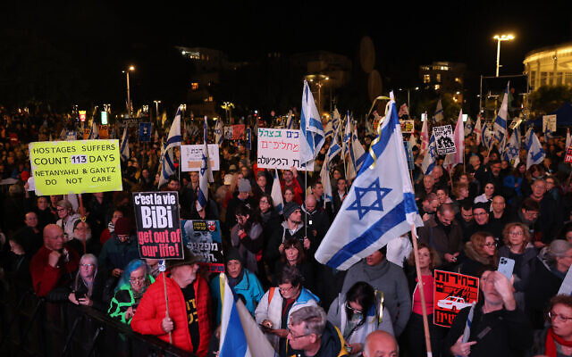 Des manifestants tiennent des drapeaux et des pancartes exigeant la démission du gouvernement et des élections anticipées, dans le cadre de la guerre en cours à Gaza, lors d'un rassemblement à Tel Aviv le 27 janvier 2024. (Crédit : Ahmad Gharabli/AFP) Des manifestants tiennent des drapeaux et des pancartes exigeant la démission du gouvernement et des élections anticipées, dans le cadre de la guerre en cours à Gaza, lors d'un rassemblement à Tel Aviv le 27 janvier 2024. (Crédit : Ahmad Gharabli/AFP)