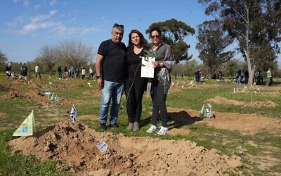 La présidente du KKL-JNF Ifat Ovadia-Luski avec Doron et Meirav Madar, les parents de  Shahak Yosef Madar,tué le 7 octobre, plantent un eucalyptus sur le site du massacre de la rave Supernova, à Reim, en hommage aux victimes. (Crédit : Yossi Ifergan/KKL-JNF Archive via JTA)