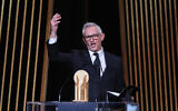 Gary Lineker, ancien footballeur anglais devenu présentateur de télévision sportive, faisant un geste sur scène avec le trophée Gerd Muller du meilleur attaquant lors de la cérémonie de remise du Ballon d'Or France Football 2023, au théâtre du Châtelet, à Paris, le 30 octobre 2023. (Crédit : Franck Fife/AFP)