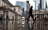 Des personnes passent devant le bâtiment de la Banque d'Angleterre (à gauche) et le bâtiment de la Bourse (à droite), dans le quartier financier au centre de Londres, le 2 novembre 2023. (Crédit : HENRY NICHOLLS / AFP)
