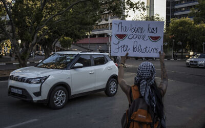 Photo d'illustration : Un activiste pro-palestinien tient un panneau avec des images de tranches de pastèque à Johannesburg, en Afrique du sud, le 24 novembre 2023. (Crédit : Davide Longari/AFP)