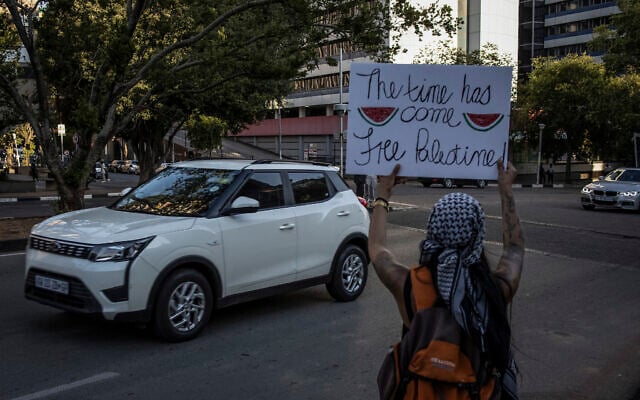 Photo d'illustration : Un activiste pro-palestinien tient un panneau avec des images de tranches de pastèque à Johannesburg, en Afrique du sud, le 24 novembre 2023. (Crédit : Davide Longari/AFP)