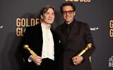 L'acteur irlandais Cillian Murphy et l'acteur américain Robert Downey Jr. posant dans la salle de presse avec les prix de la meilleure performance masculine dans un film dramatique et de la meilleure performance masculine dans un second rôle lors de la 81e édition des Golden Globe Awards, à l'hôtel Beverly Hilton de Beverly Hills, en Californie, le 7 janvier 2024. (Crédit : Robyn Beck/AFP)