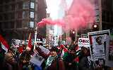 Des activistes brandissant des drapeaux et des pancartes lors d'une "marche nationale pour la Palestine", dans le centre de Londres, le 13 janvier 2024. (Crédit : Henry Nicholls/AFP)