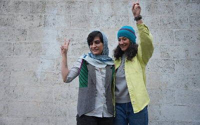 Cette photo, prise et diffusée par le site d'information Sharq News le 14 janvier 2024, montre les journalistes iraniennes Niloufar Hamedi (à droite) et Elaheh Mohammadi (à gauche) faisant le signe de la victoire après leur libération de la prison d'Evin sous caution à Téhéran. Les autorités iraniennes ont libéré deux journalistes qui ont passé plus d'un an derrière les barreaux pour avoir couvert la mort de Mahsa Amini, déclenchant des protestations nationales de plusieurs mois, selon les médias locaux. (Crédit : Sahand TAKI / Sharq news online / AFP)