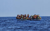 Un bateau de migrants dans les eaux méditerranéennes à l'est du cap Greco, dans le sud-est de Chypre, avant une opération de sauvetage, sur une photo du Centre conjoint de coordination des opérations de sauvetage du gouvernement chypriote, le 20 août 2023. (Crédit : Centre conjoint de coordination des opérations de sauvetage / AFP)