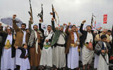 Des personnes soulevant des fusils et des pancartes alors qu'elles chantent lors d'un rassemblement anti-Israël et anti-américain dans la capitale contrôlée par les Houthis, à Sanaa, le 19 janvier 2024. (Crédit : Mohammed Huwais/AFP)