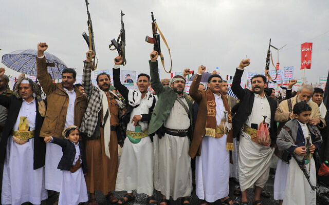 Des personnes soulevant des fusils et des pancartes alors qu'elles chantent lors d'un rassemblement anti-Israël et anti-américain dans la capitale contrôlée par les Houthis, à Sanaa, le 19 janvier 2024. (Crédit : Mohammed Huwais/AFP) Des personnes soulevant des fusils et des pancartes alors qu'elles chantent lors d'un rassemblement anti-Israël et anti-américain dans la capitale contrôlée par les Houthis, à Sanaa, le 19 janvier 2024. (Crédit : Mohammed Huwais/AFP)