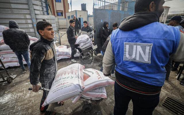 Des Palestiniens déplacés reçoivent une aide alimentaire au centre de l'Office de secours et de travaux des Nations unies pour les réfugiés de Palestine (UNRWA) à Rafah, dans le sud de la bande de Gaza, le 28 janvier 2024. (Crédit : AFP)