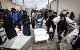 Des Palestiniens déplacés reçoivent une aide alimentaire dans un centre de l'UNRWA à Rafah, dans le sud de Gaza, le 28 janvier 2024. (Crédit :  AFP)